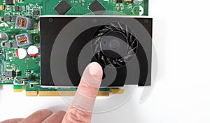 A finger points to the dust in the fan of the graphics card