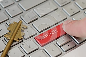 A finger press a button with text unlock on a keyboard