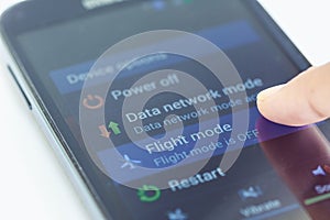 Finger press flight mode button on smartphone