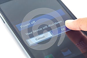 Finger press power off button on smartphone