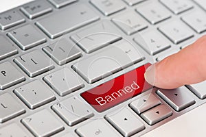 A finger press red banned button on laptop keyboard