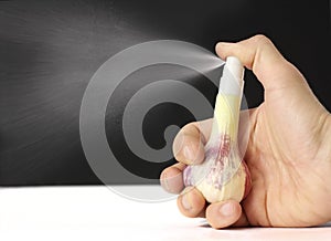 Finger presses on garlic dispenser, small splashes, concept of vitamin supplements, virus protection, herbal homeopathy