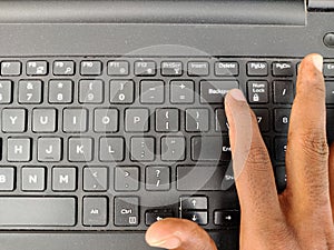 Finger pressing a backspace button on the