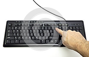 Finger pressing Backspace button on the black keyboard