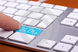 Finger pressing on blog button on keyboard
