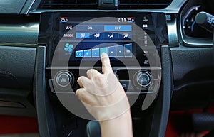 Finger pressing the button adjust speed the air conditioner in the modern car dashboard