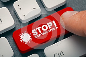 Finger pressing computer key with stop coronavirus word and symbol