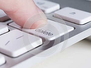 Finger is pressing delete key of computer keyboard