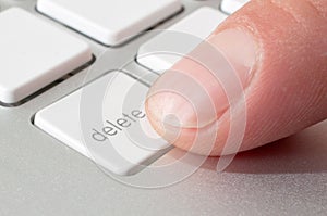 Finger pressing a DELETE key