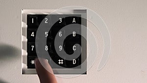 Finger Pressing Elevator Button Panel. Close-up of a finger pressing a button on a numeric keypad in an elevator.