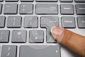 Finger pressing the enter key on keyboard