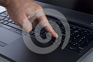 Finger Pressing the Enter Key on a Laptop Keyboard