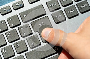 Finger pressing the enter key on a sleek, modern design keyboard, confirmation, command execution, chatting and sending a message