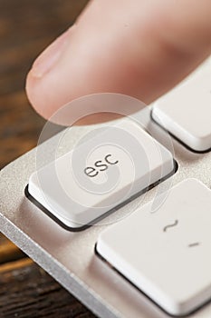 Finger Pressing Escape on a Grey Computer Keyboard