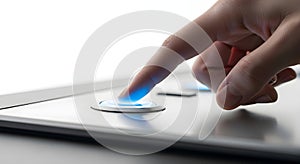 Finger pressing a glowing blue button on a modern device