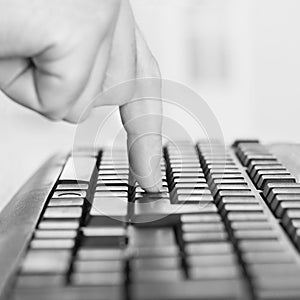 Finger pressing a key on a computer keyboard