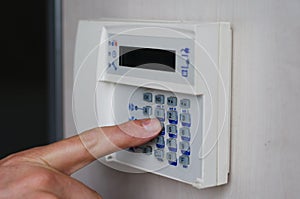 Finger pressing keys on alarm keypad