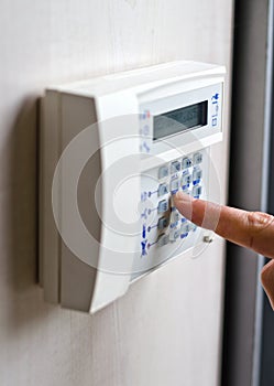 Finger pressing keys on alarm keypad