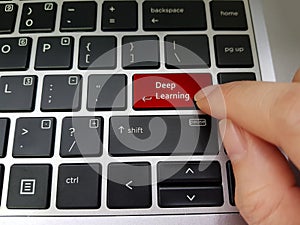 Finger pressing a laptop key with the word Deep Learning