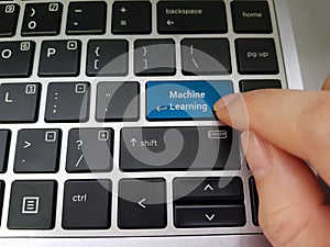 Finger pressing a laptop key with the word Machine Learning