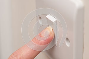 Finger Pressing ON Light Switch on Wall COPY SPACE