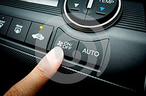 Finger pressing on Power switch of Car air conditioning system