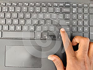 Finger pressing a shift button on the laptop