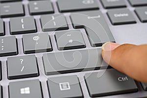 Finger pressing the shift key on keyboard