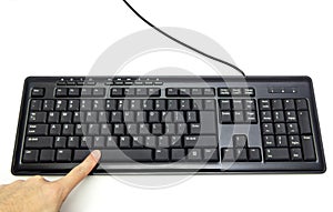 Finger pressing Spacebar button on the black keyboard photo