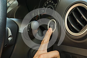 Finger pressing start and stop button for a modern Eco car