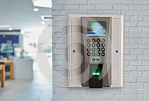 Finger print scan machine on brick wall.