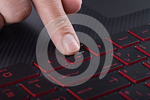 Finger pushing arrow button on laptop keyboard