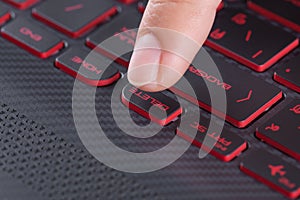 Finger pushing delete button on laptop keyboard
