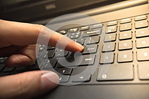 Finger pushing the Enter button of keyboard