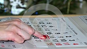 Finger pushing paper calendar marker till Christmas holiday