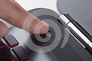 Finger pushing power button on laptop keyboard