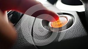 Finger is pushing start button of automobile`s engine