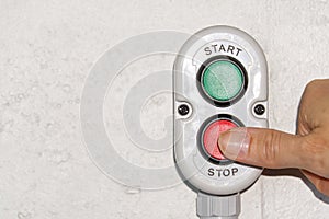 A finger pushing a stop button on production.
