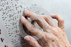 Finger reading braille tactile on public park message board