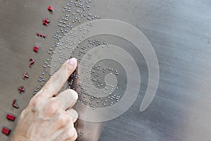 Finger reading braille tactile on public park message board