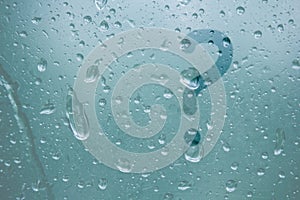 Finger-shaped pattern of question mark stripes on translucent fogged glass. raindrops of spring rain on the window close-up.