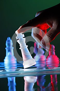 Finger tilting a chess piece on Chess Board