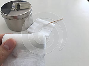 Finger tip hold roll gauze on blur swab and gauze jar in medical concept