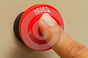 Finger touch on red emergency stop switch