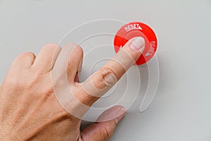 Finger touch on red emergency stop switch and reset