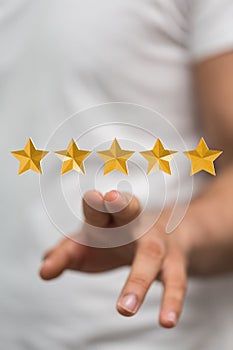 Finger touching a 3d rendering of a five star rating