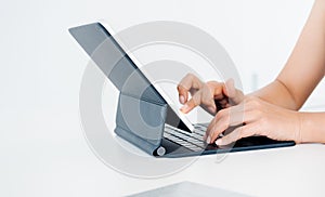 Finger touching and click on digital tablet screen while typing on keyboard computer  on white background.