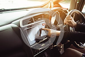 Finger touching and turning on car radio system,Woman driver hands holding steering wheel