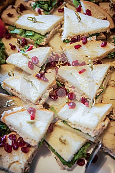 Finger of wedge sandwiches arranged on a platter.