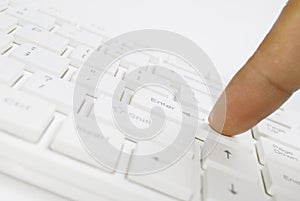 Finger on white computer keyboard